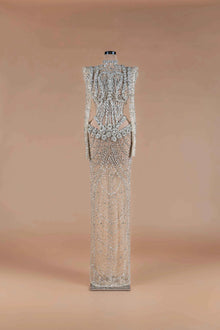 Sihëna Prismatic Cascade — silver high-neck long-sleeve column gown encrusted with crystal and beadwork on sheer nude tulle.
