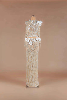 Sihëna Ivory Camellia — champagne high-neck long-sleeve sheer lace gown with silver beadwork and ivory 3D camellia florals.