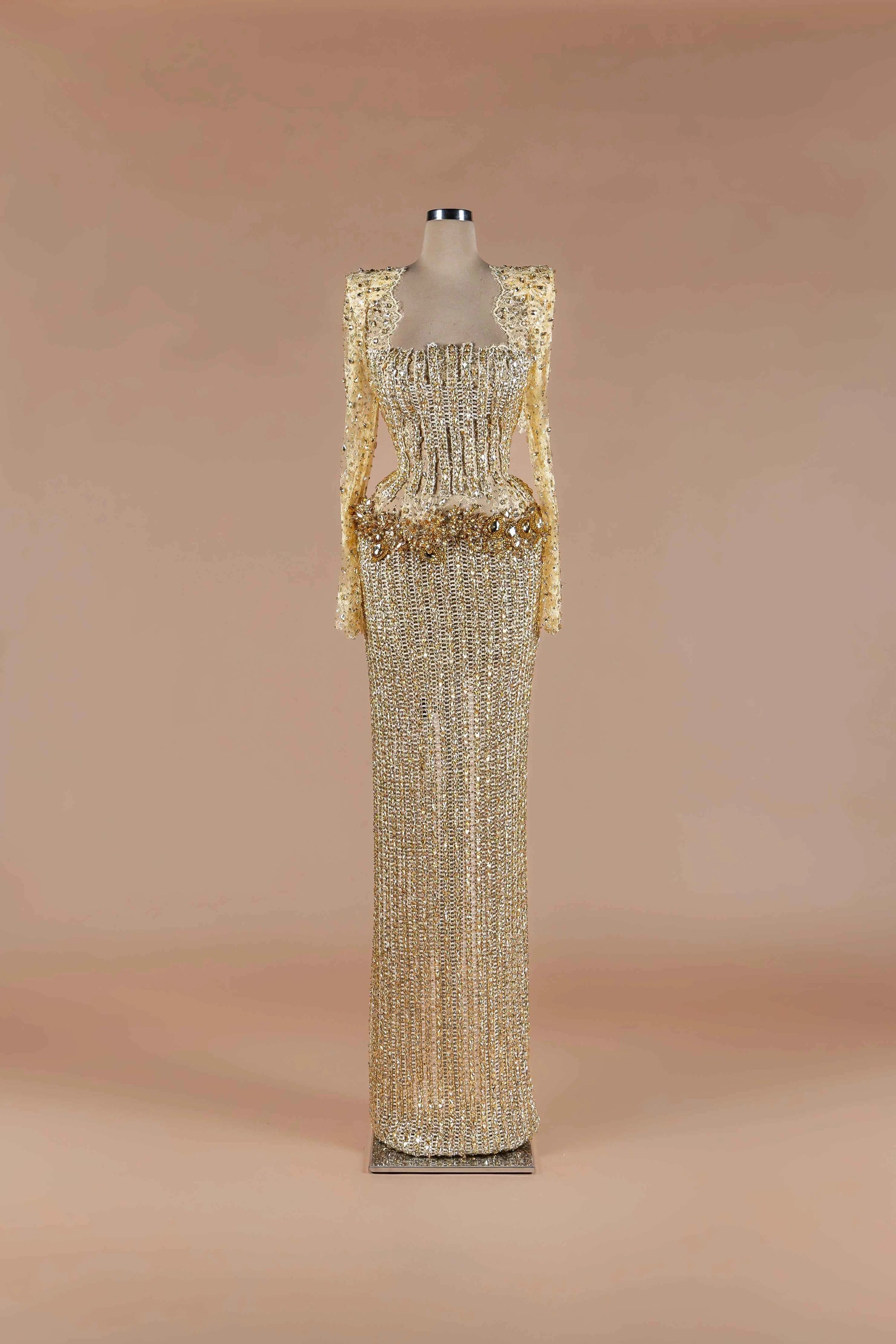 Sihëna Gilded Corset Column — gold square-neck long-sleeve crystal corset gown with beaded lace sleeves and column skirt.