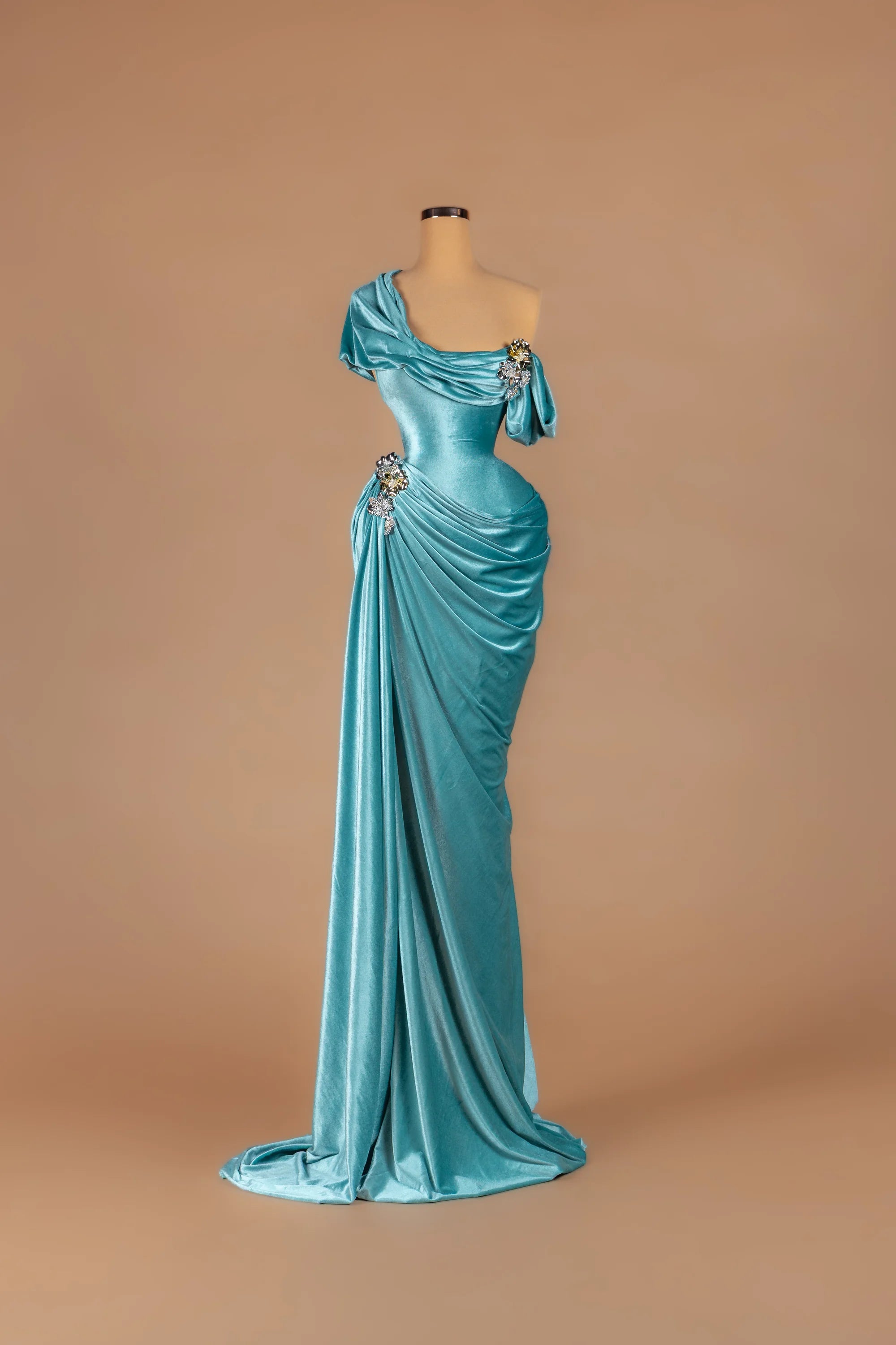 Sihëna Aegean Tide — teal asymmetric off-shoulder fitted gown with crystal accents on draped velvet.