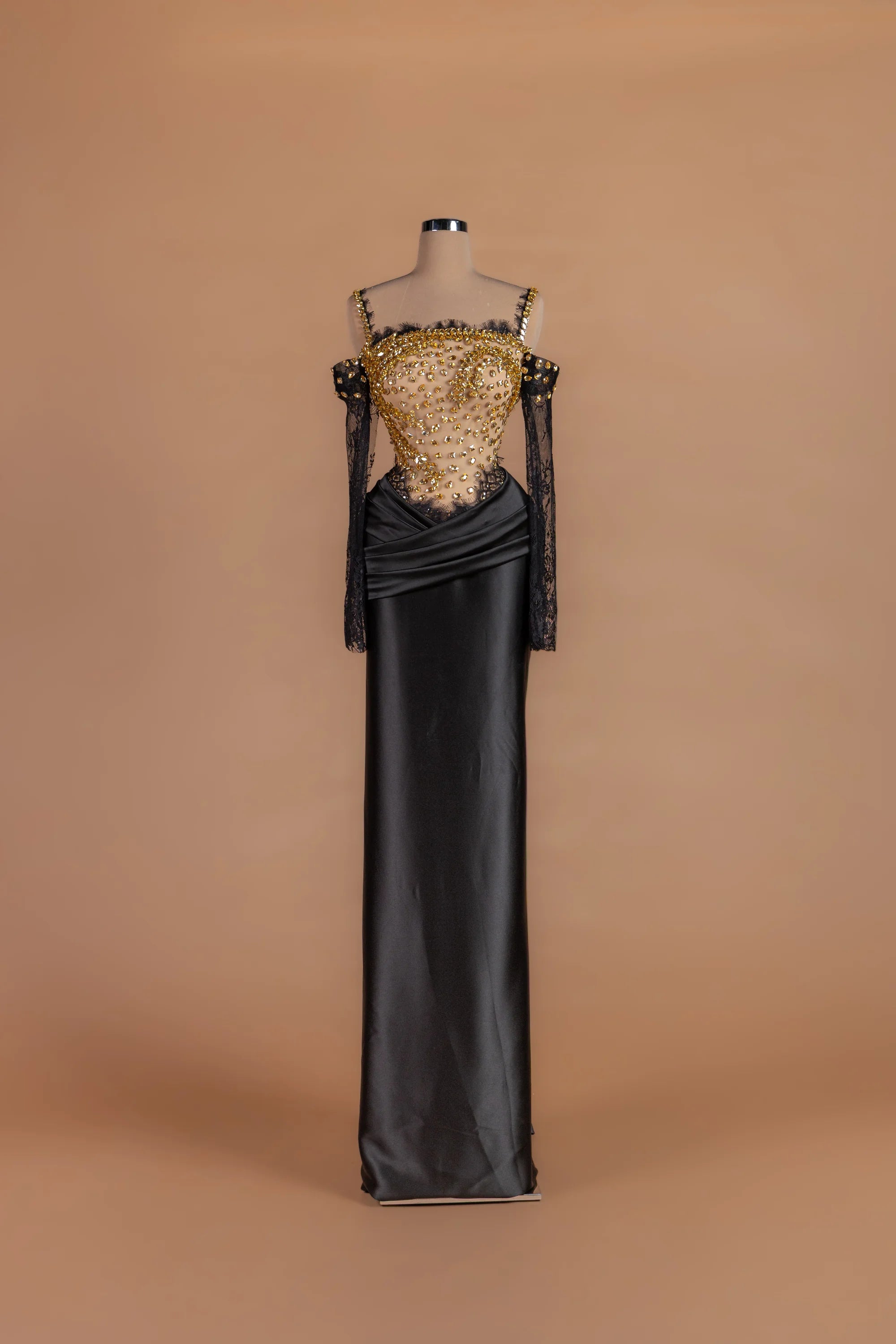 Sihëna Ember Eventide — black square-neck off-shoulder column gown with gold crystal beading on a sheer bodice.