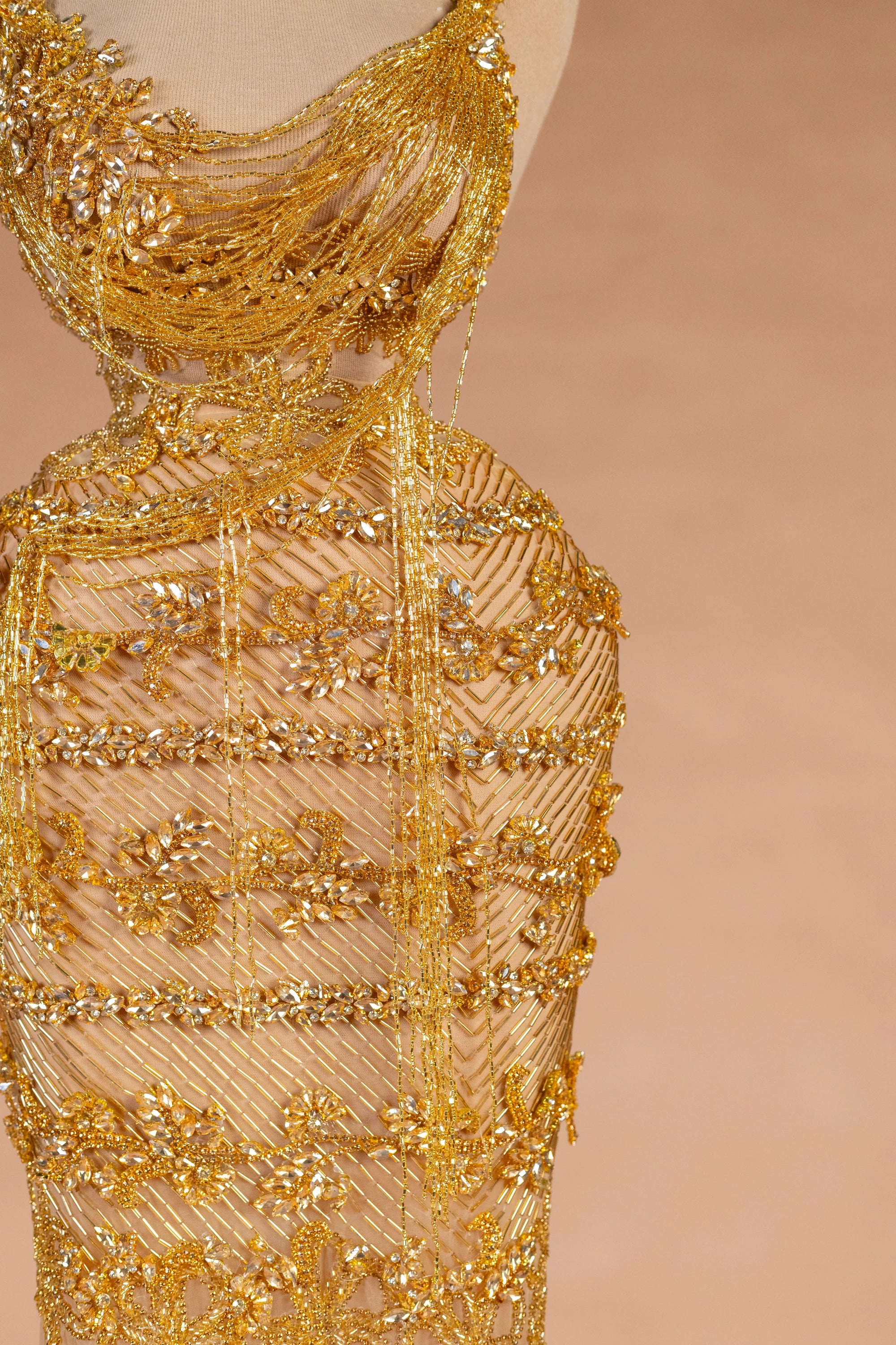 Sihëna حِلْيَةُ التِّبْر — gold asymmetric sleeveless column evening dress
