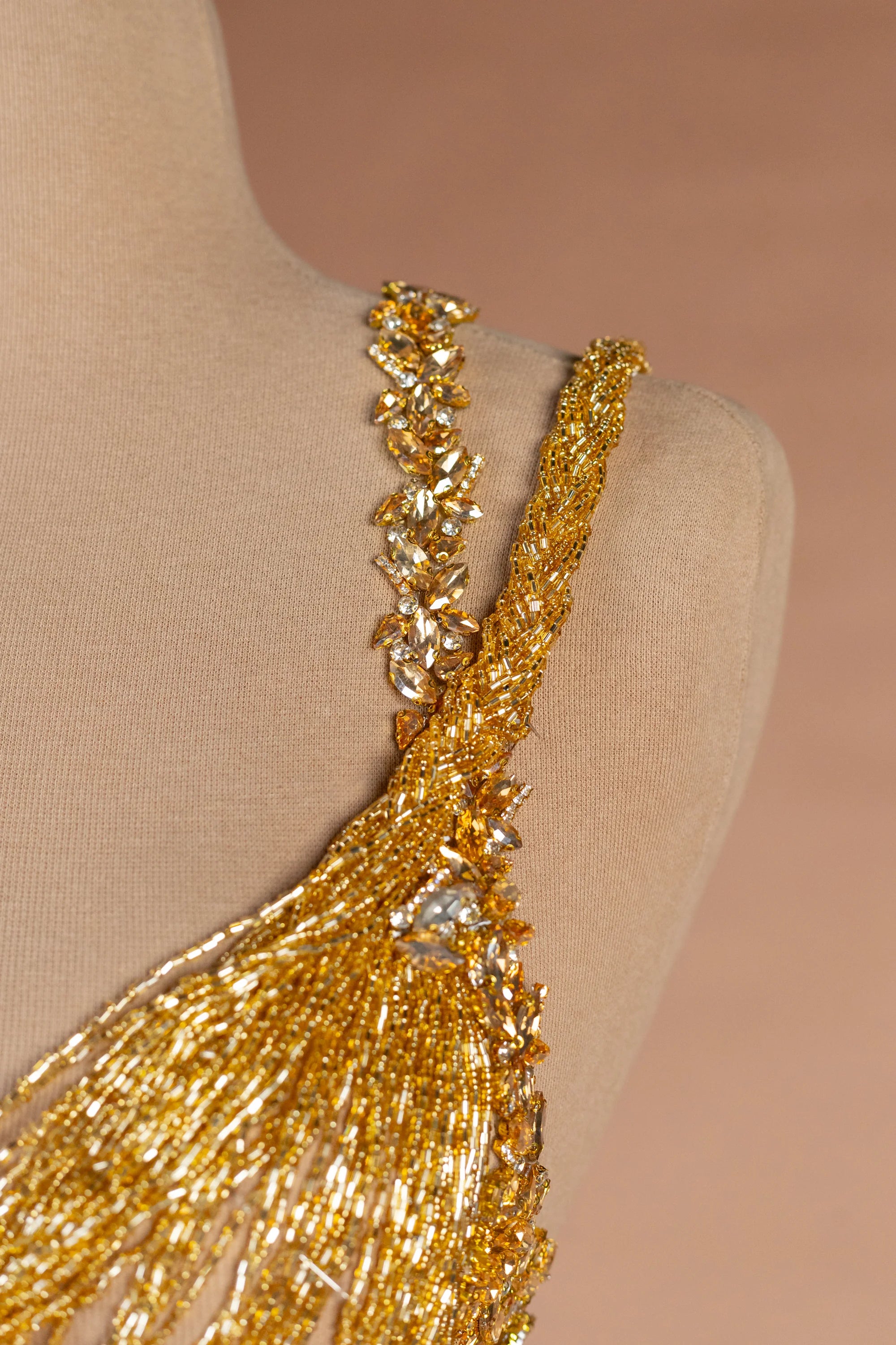 Sihëna حِلْيَةُ التِّبْر — gold asymmetric sleeveless column evening dress