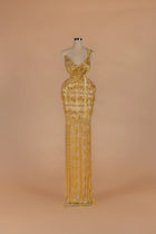 Sihëna Gilded Parure — gold asymmetric sleeveless column gown with draped crystal bead strands.