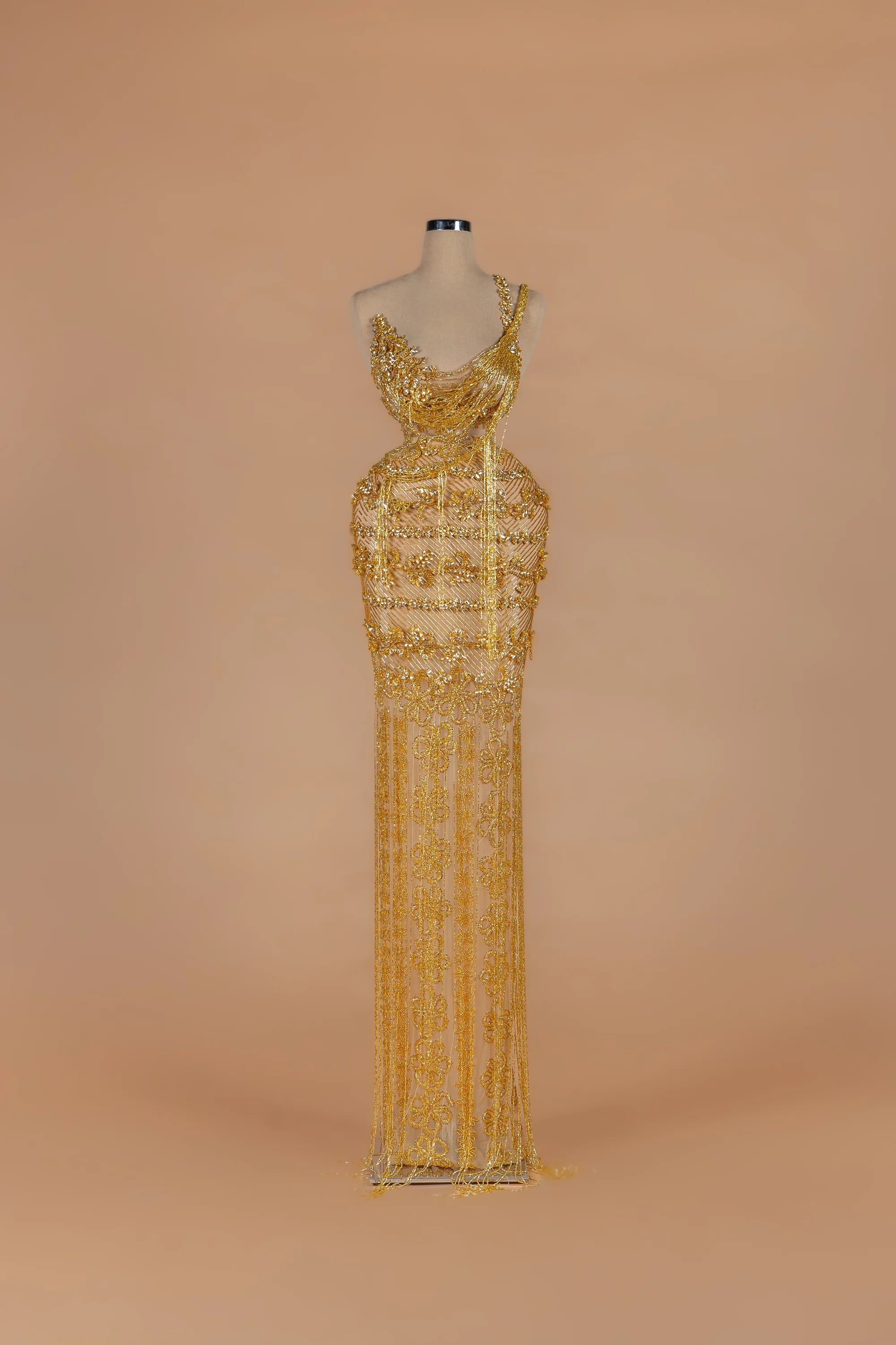 Sihëna Gilded Parure — gold asymmetric sleeveless column gown with draped crystal bead strands.