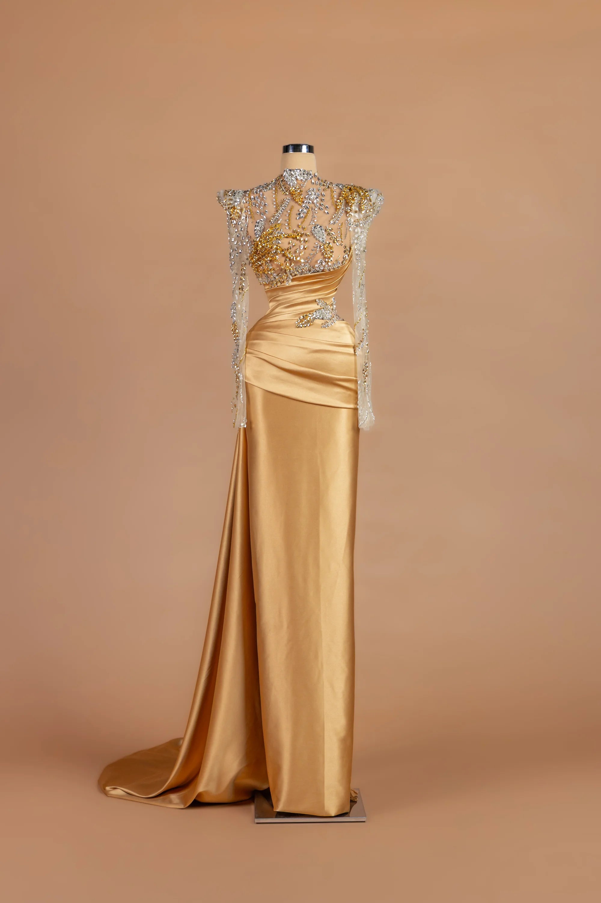 Sihëna Goldleaf Regent — gold high-neck long-sleeve column gown with leaf-motif crystal embroidery.