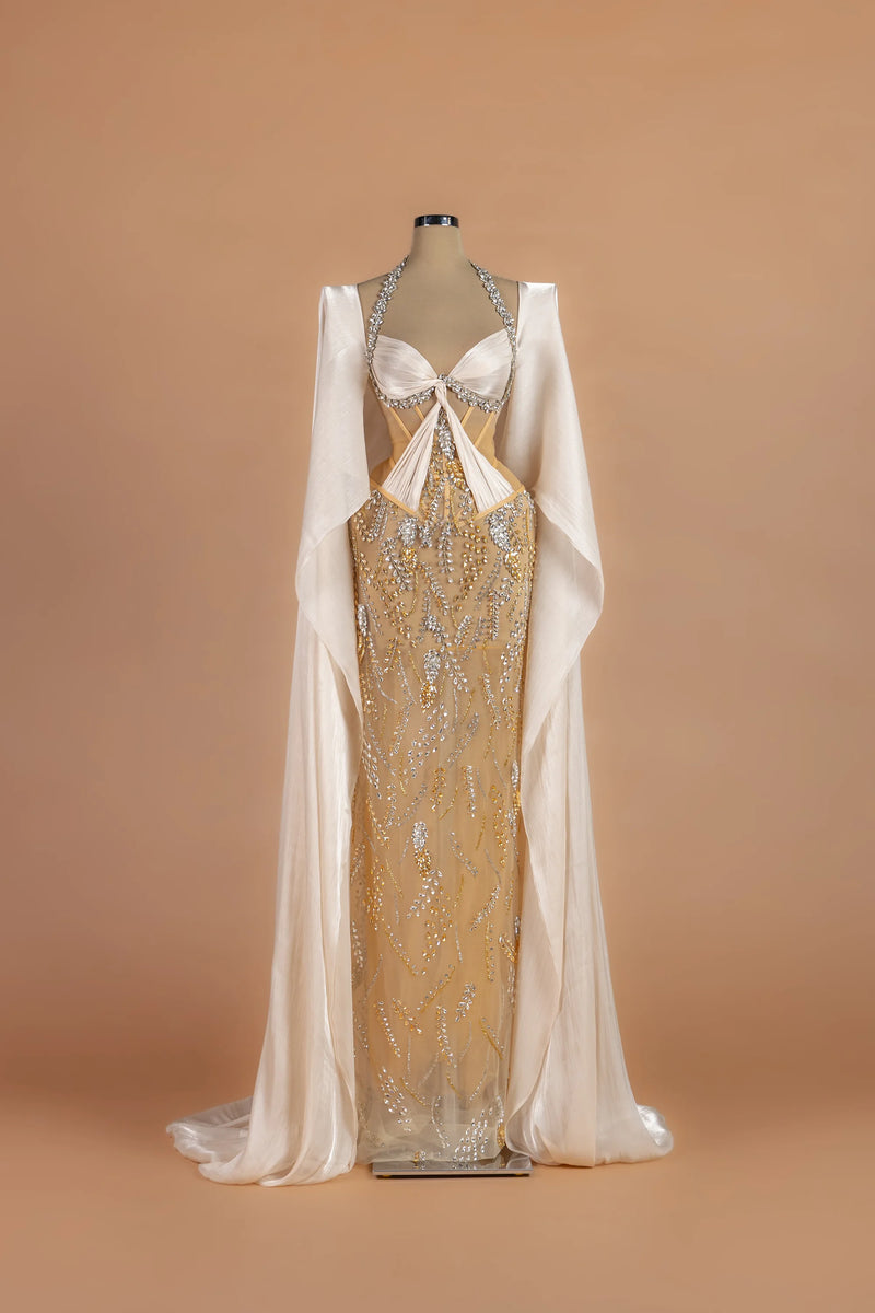 Sihëna Gossamer Moonrise — champagne halter cape-sleeve column gown with a crystal-trimmed corset bodice.