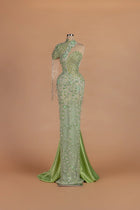 Sihëna Peacock Regalia — sage-green asymmetric sleeveless mermaid gown with crystal beading.