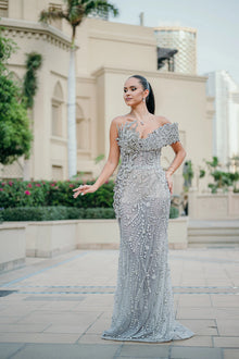 Sihëna Platinum Aigrette — silver sweetheart off-shoulder column gown with looping crystal chains and teardrop stones.