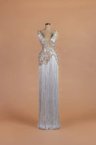 Sihëna Sterling Cloudburst — silver v-neck sleeveless column gown with beaded fan-motif bodice over a fringe skirt.
