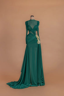 Sihëna Sylvan Oracle — emerald illusion-neck long-sleeve a-line gown with a gold crystal cluster at the draped hip.